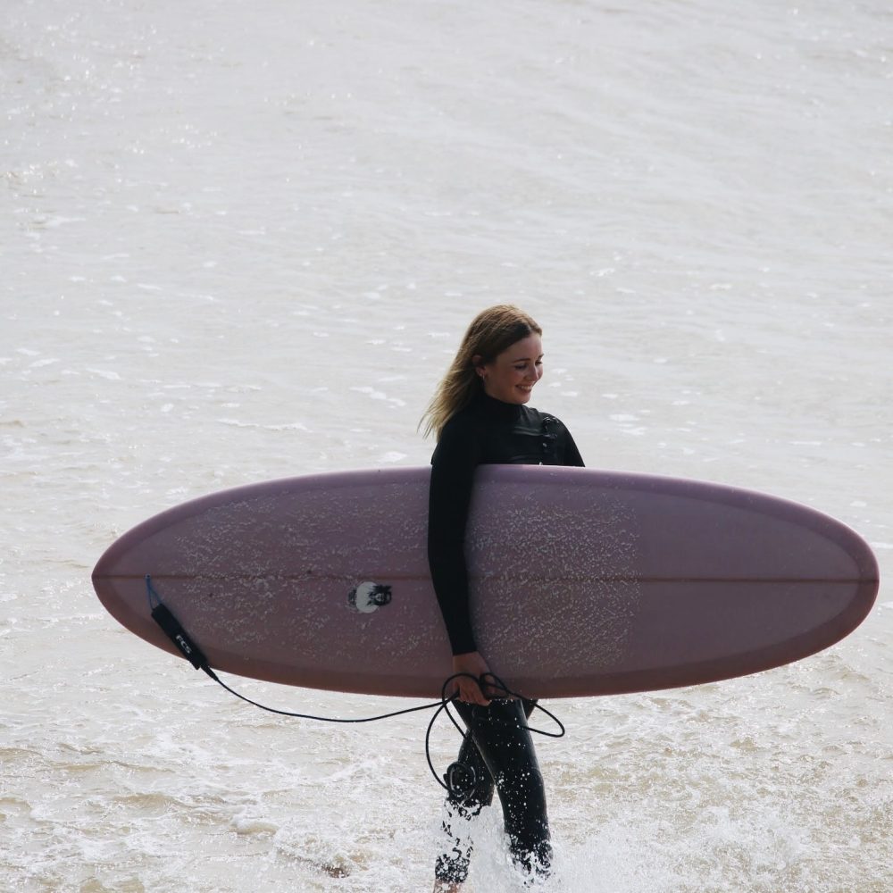 woman carrying surfboard
