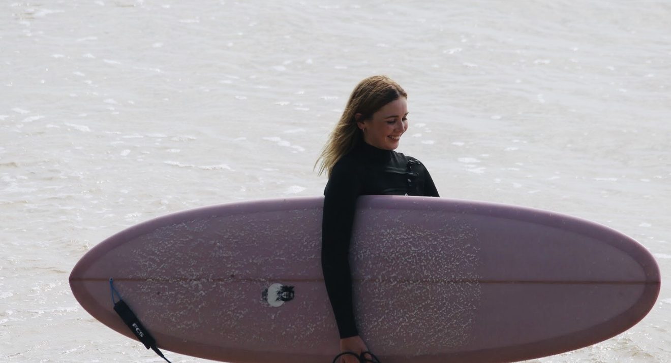 woman carrying surfboard