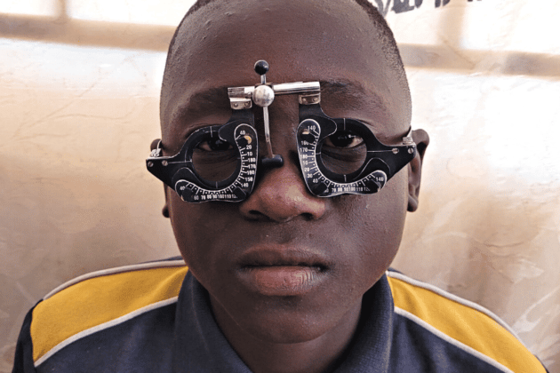 Young africa boy having his eyes tested by an optometrist in Zambia