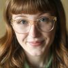 Ayo Citrine 2023 woman wearing oversized feminine glasses with a sweeping brow line in crystal citrine. Handmade in Italy from eco-friendly bio-acetate.