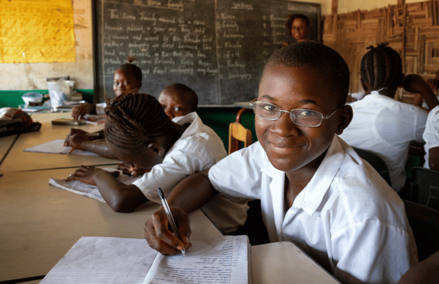 Teenage boy wearing glasses in class at a school in Africa,