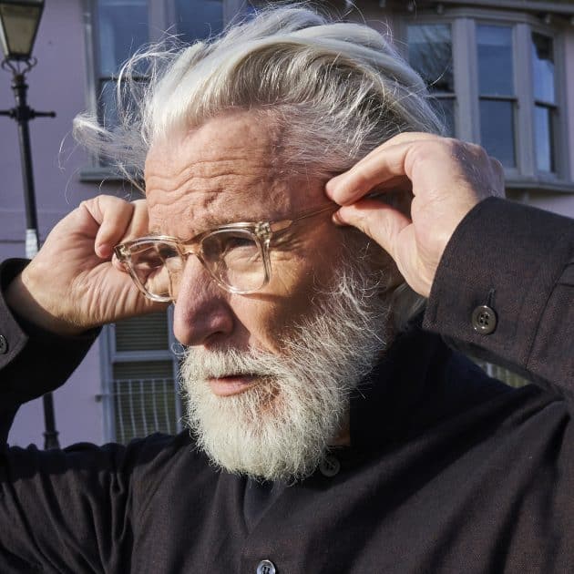 Man wearing sustainable square prescription glasses in smoke quartz crystal frame. Available with blue light blocking lenses.