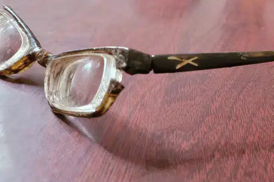 Severely broken prescription glasses that have been worn for 31 years before being replaced by Pala Spectacles.